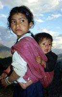 Young girl carrying her baby brother
